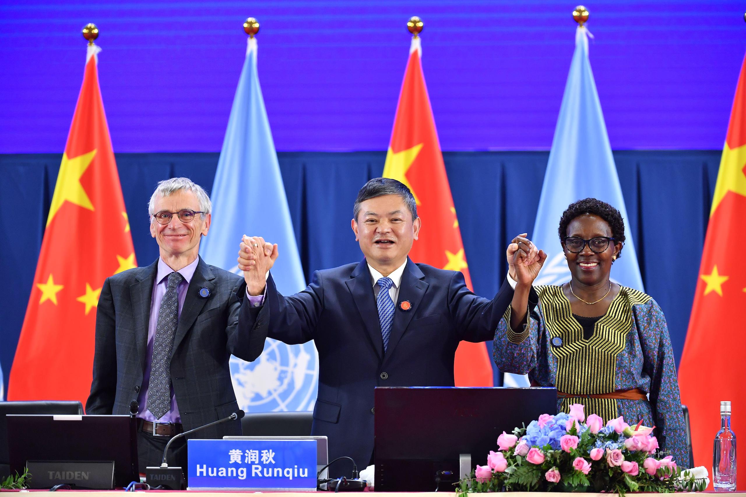 Chinese minister for ecology and environment Huang Runqiu (centre) holding hands at the first phase of COP15 biodiversity summit in Kunming, 2021