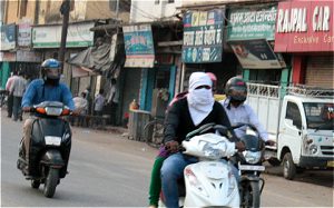 woman in Varanasi covers her face protecting herself from air pollution