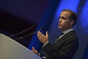 Bank of England Governor Mark Carney speaking on a podium. He sounded a warning that the huge cost of environmental disasters related to climate change is major risk for the financial sector