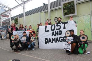 activists holding sign saying 'lost and damage'