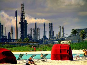 <p>Oil refineries, like this one at &quot;Baby Beach&quot; in Aruba, are supported by government payments. (Image&nbsp;by Spencer Thomas)</p>