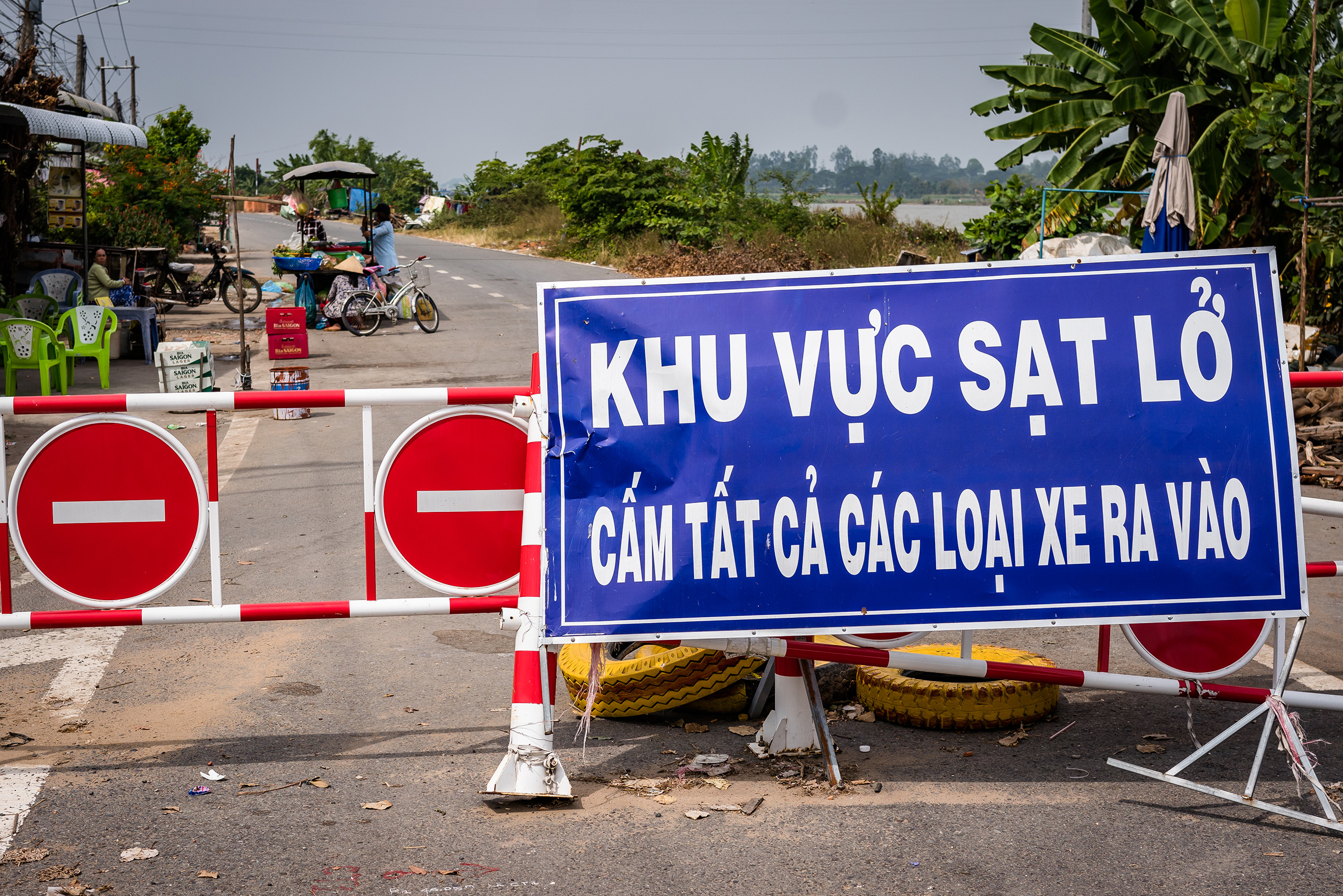 Behind a sign that warns drivers to steer clear, shopkeepers wait for customers.