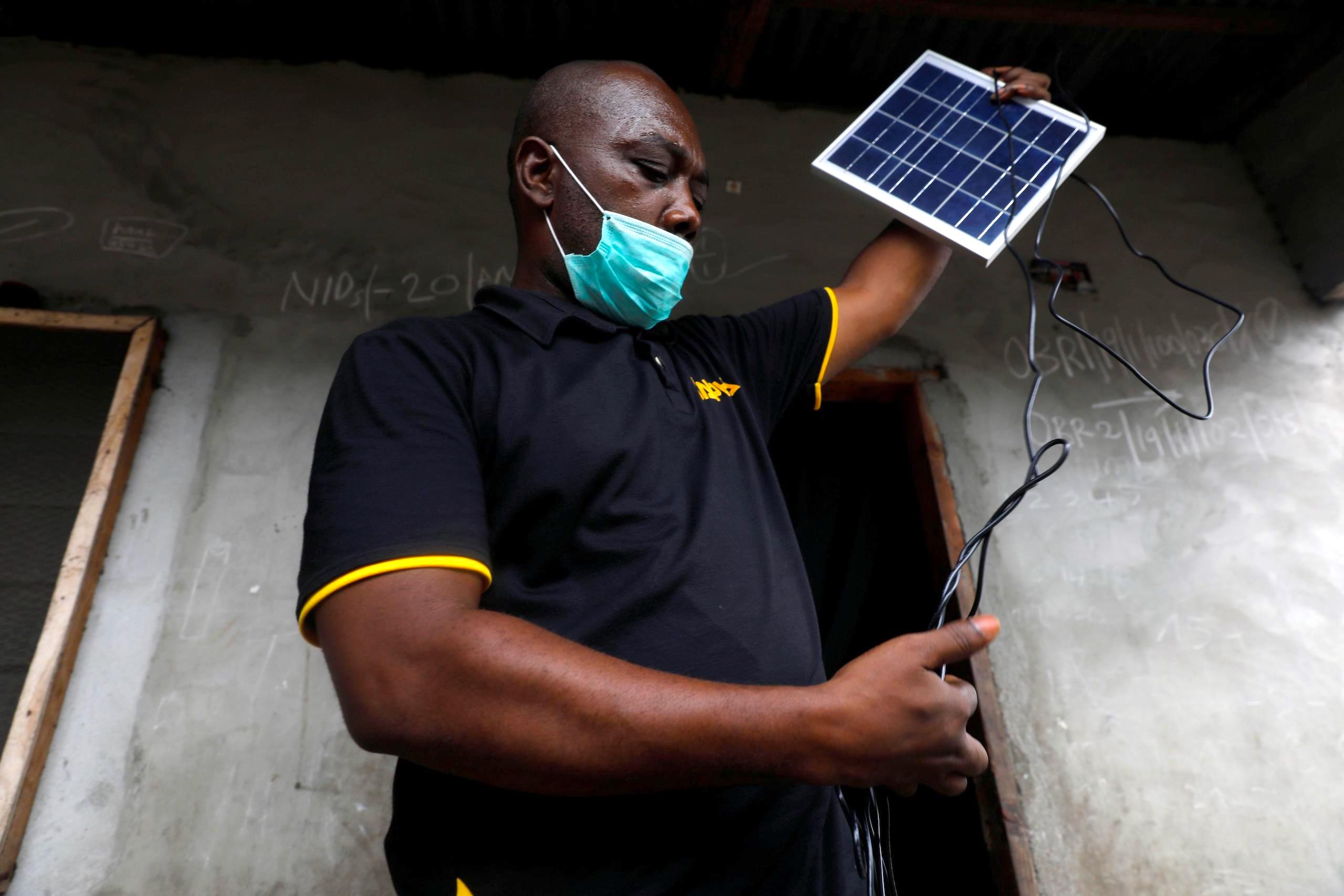 An employee of Salpha Energy unboxes a solar panel in petrostate Nigeria