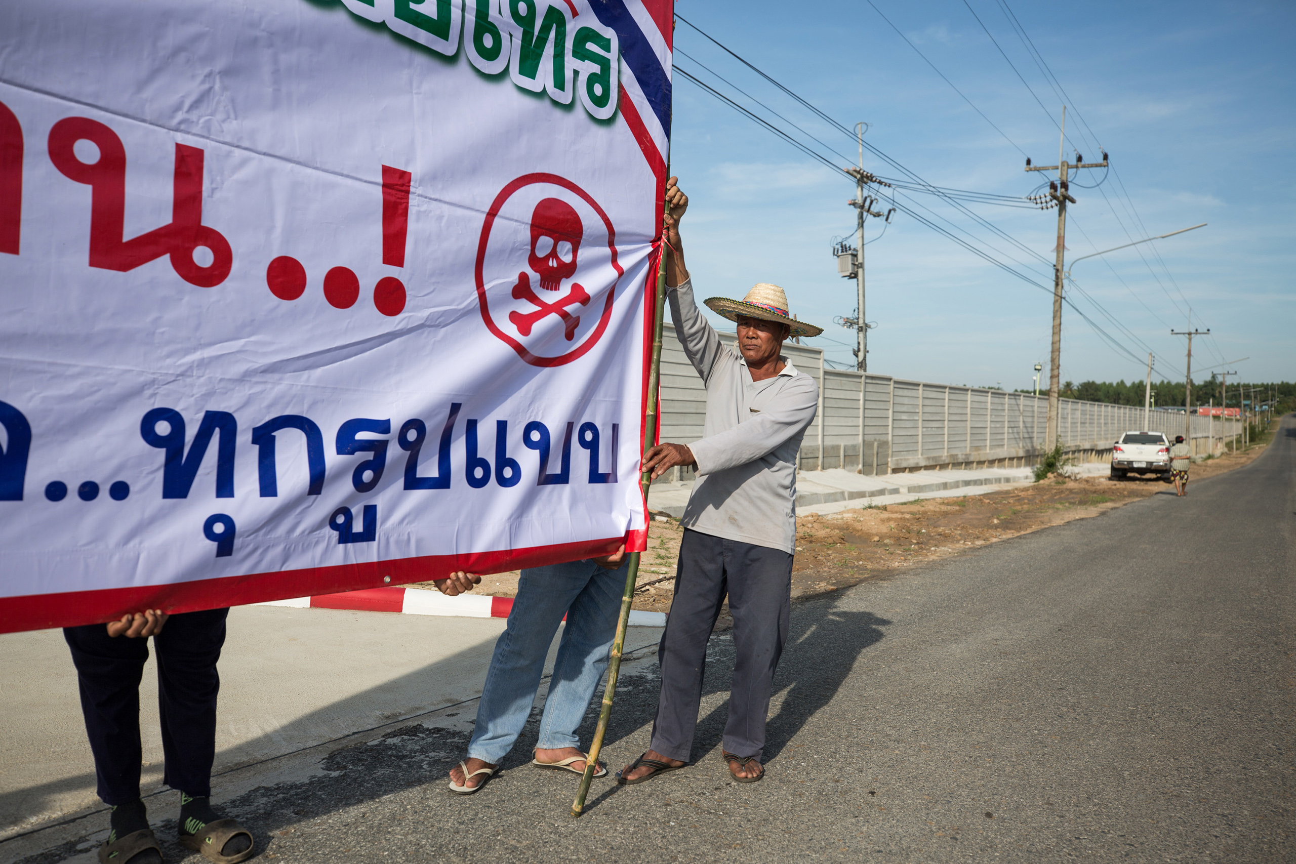 Local villagers in Bo Thong, Chonburi, protest with banners outside the industrial state that plans to become a recycling plant for plastics.