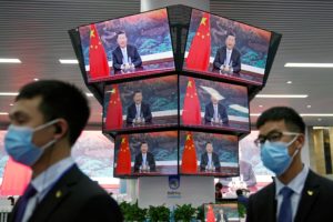 China's President Xi Jinping is seen on screens