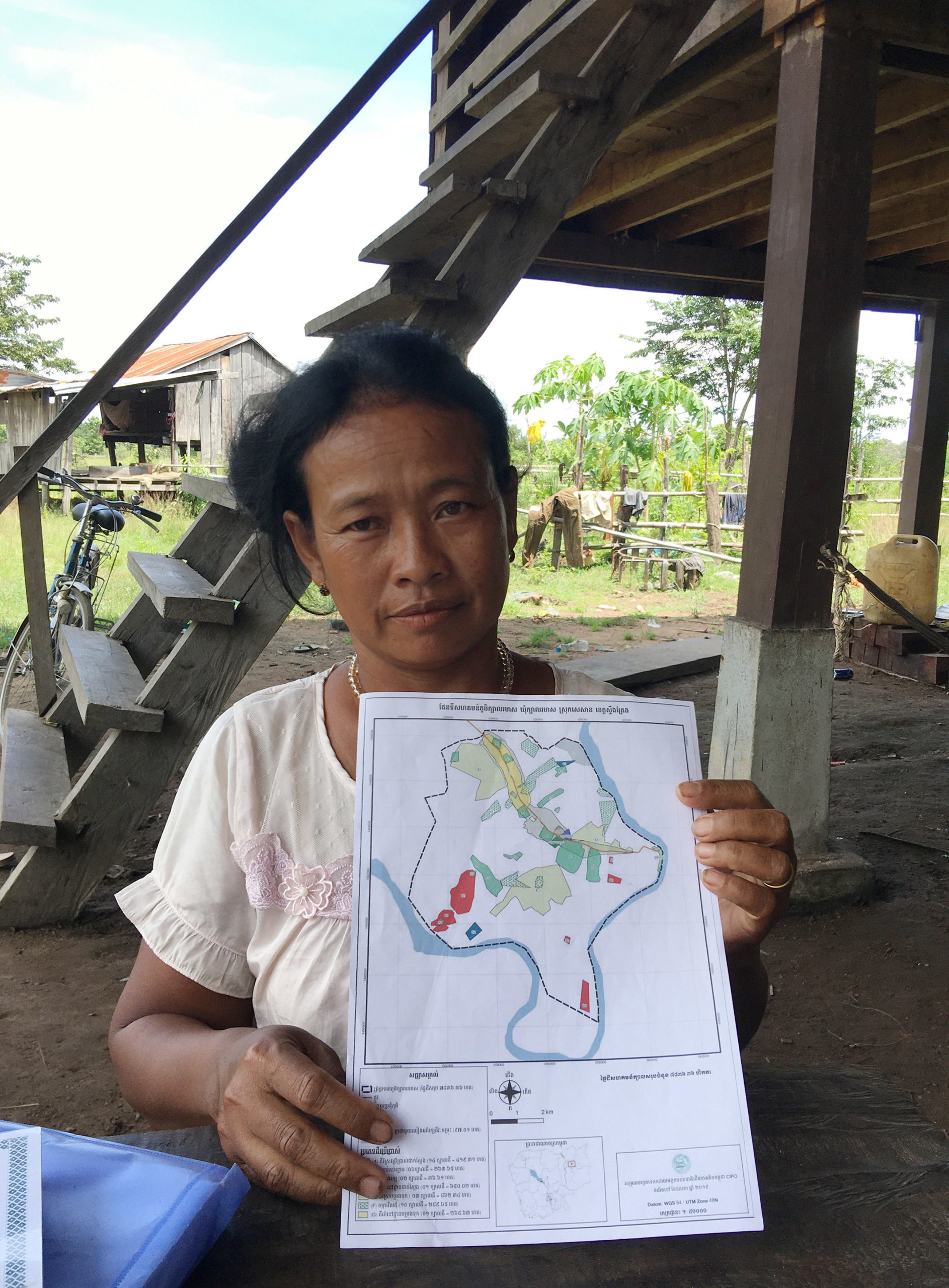 Cambodian woman holds map of the new village where people displaced by lower sesan dam have relocated