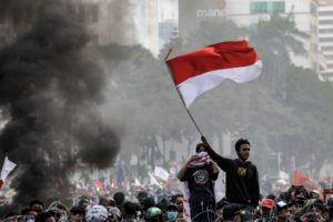 <p>A protestor waves the Indonesian flag during a demonstration against the country’s new omnibus law in October 2020 (Image: Alamy)</p>