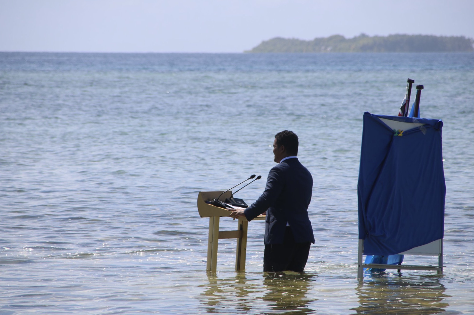 tuvalu foreign minister Simon Kofe gives a COP26 speech knee deep in water to highlight the impact of sea level rise on low-lying islands