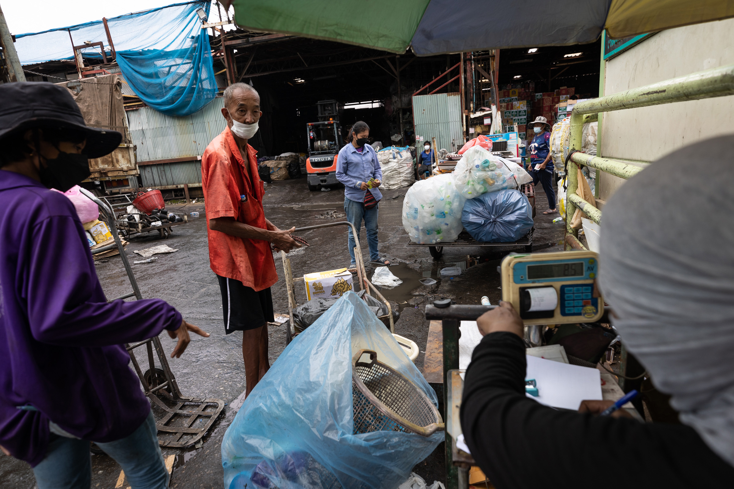 A saleng driver unloads his collected waste to be weighed at Thawat Recycling Company in Bangkok.