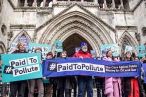 本月初，来自“有偿污染”（Paid to Pollute）组织的工作者聚集在英国皇家法院外。该组织的三名成员对英国政府提起诉讼，质疑政府利用公共资金支持石油和天然气行业。图片来源：Sabrina Merolla / Alamy