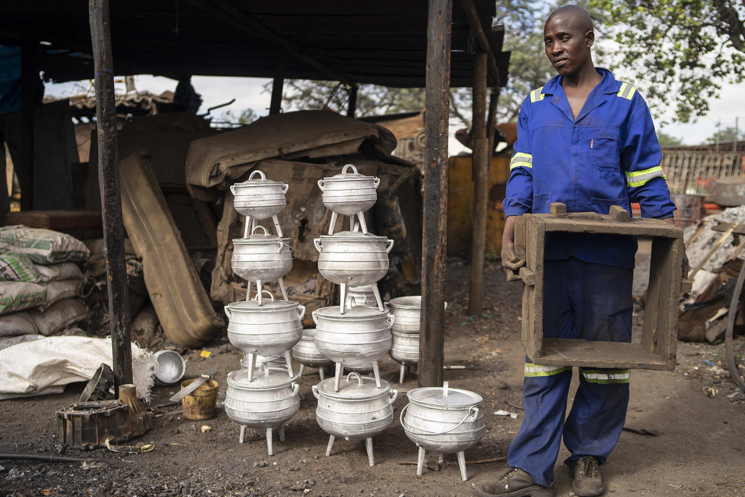 Lowani Ncube melts scrap metal cans to make aluminium pots at his informal workshop in Bulawayo