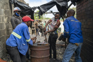 Workers in Zimbabwe melt scrap metal with coke and use traditional smithing techniques to fashion small steel items