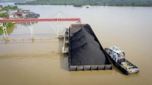 Coal is loaded onto a barge in Indonesian Borneo. The country is planning to build a new coal gasification industry to make use of excess supply, despite its pledge at COP26 to move away from the fuel. (Image: Ariyanto Ariyanto / Alamy)