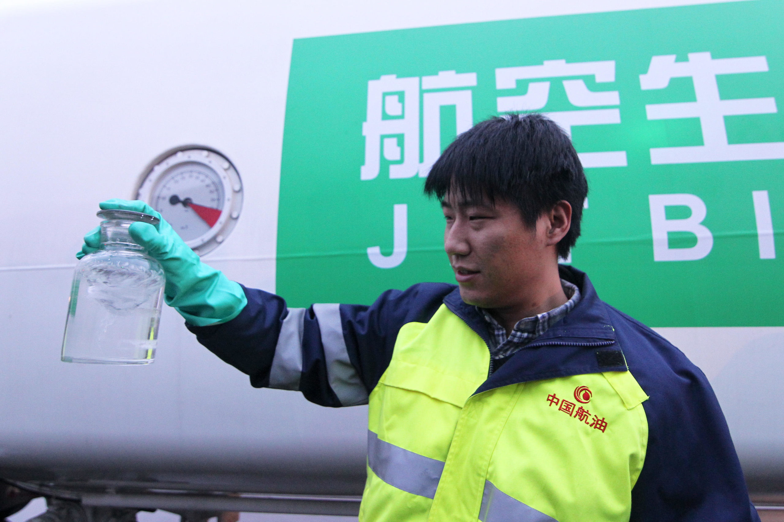 Man in hi vis jacket holding transparent bottle of clear liquid