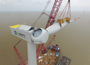 China: workers hoisting a wind turbine blade in an offshore wind power plant