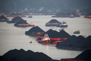 <p>Coal barges ready to be pulled up the Mahakam River in Samarinda, East Kalimantan. Indonesia is reliant on coal for about 60% of its power. (Image: Reuters/Alamy)</p>