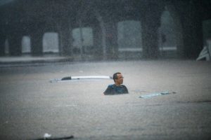 View of a person trying to swim across the floodwater caused by torrential rain in Zhengzhou, China