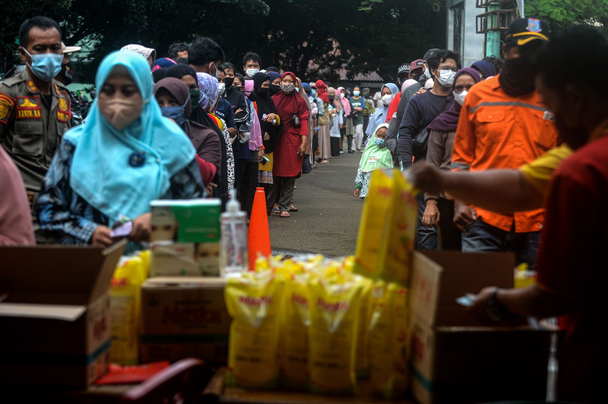 Long queues of people waiting for packets of cooking oil
