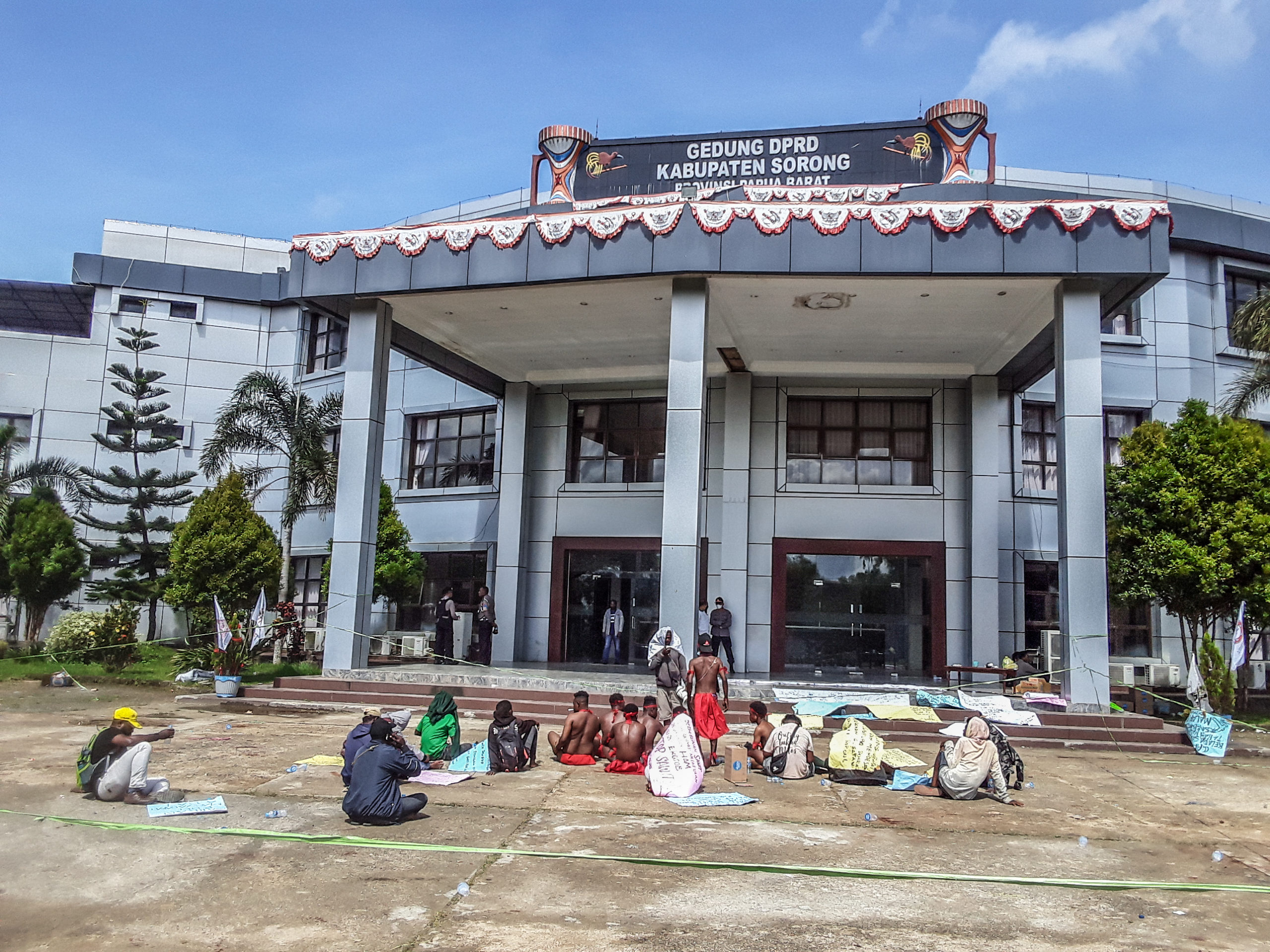 People sitting on the ground outside a building