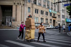 <p>Shanghai residents transport boxes of food during lockdown (Image: Aly Song / Alamy)</p>