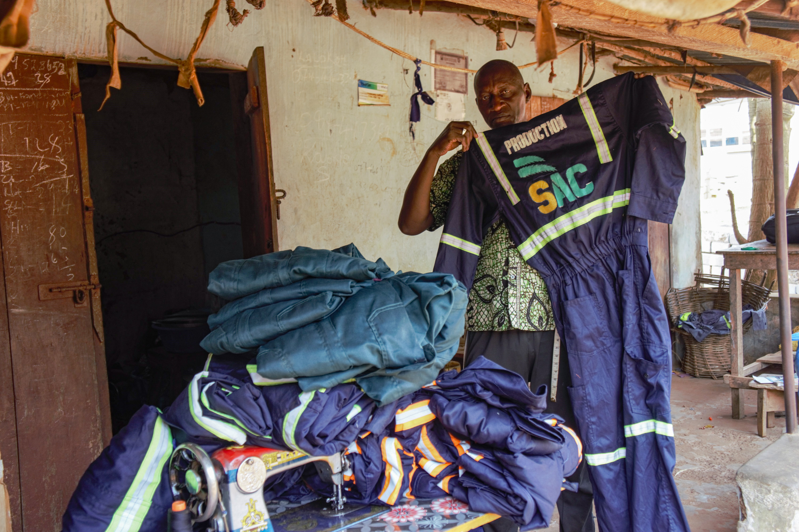 Tailor Mohamed Keita benefits from a contract to make uniforms for SAC workers