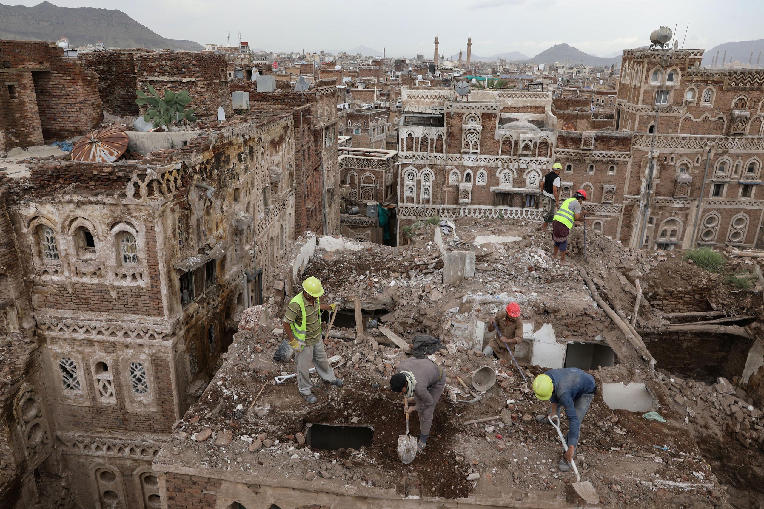 Workers demolish a building damaged by rain in the UNESCO World Heritage site of the old city of Sanaa, Yemen