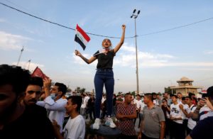 A woman demonstrator chants slogans during a protest over corruption, lack of jobs, and poor services, in Baghdad, Iraq