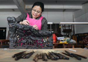 Craftswoman works on rosewood carving at a rosewood furniture factory in Guangfu Township in Suzhou, east China