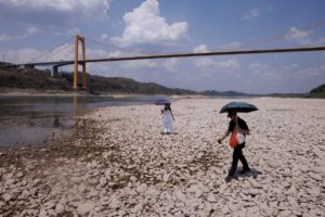 Local residents walk on dry riverbed of the Yangtze river that is approaching record-low water levels during a regional drought in Chongqing, China, August 20, 2022.