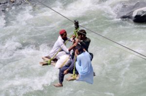 <p>People cross the Swat River, after flash floods in northwest Pakistan, on 5 September 2022. Climate scientists say that while this year’s catastrophic flooding across the country has been compounded by flash flooding in some northern districts, it occurred mainly because of torrential monsoon rains in southern districts. (Image: Saeed Ahmad / Alamy)</p>