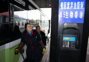 worker filling up a bus with fuel
