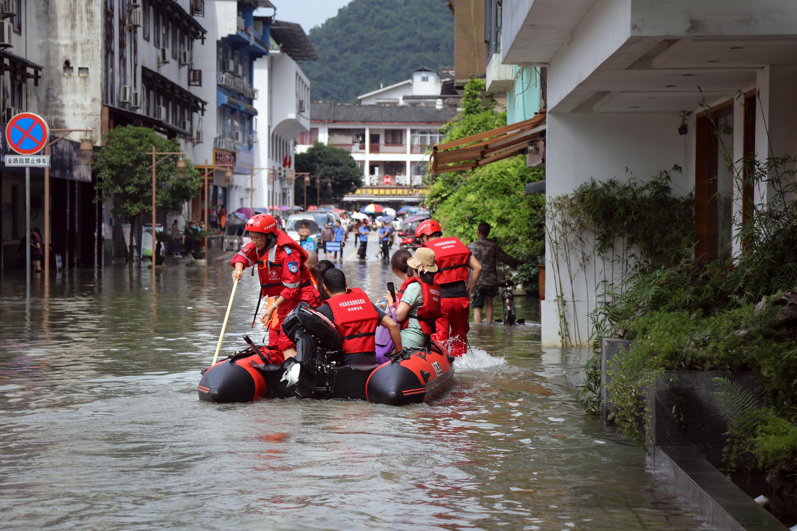Firefighters escort residents to safety during floods caused by heavy rain in Guilin, south China in June