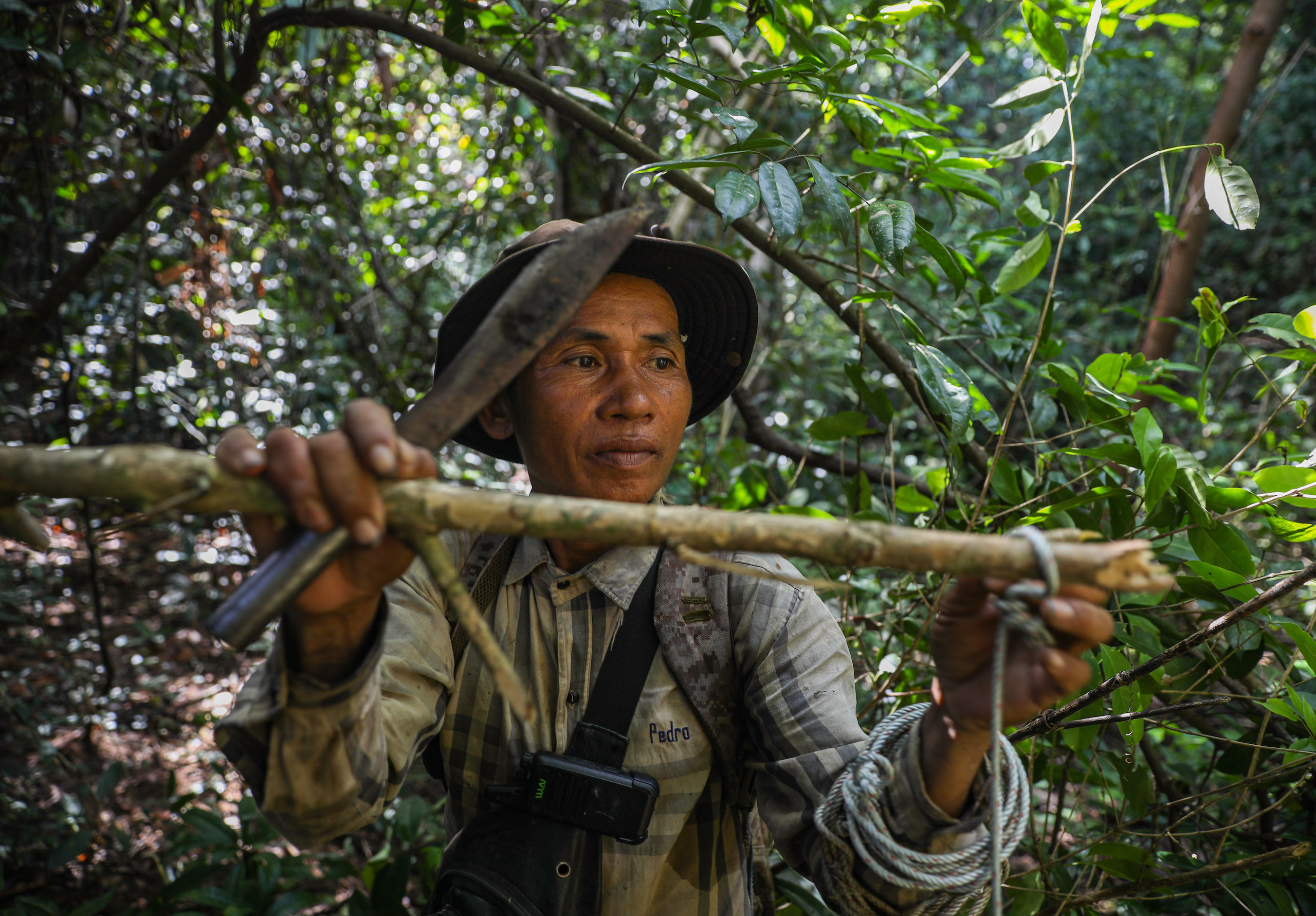 Sok Lolo removes a snare discovered during a patrol in Phnom Thnout Wildlife Sanctuary