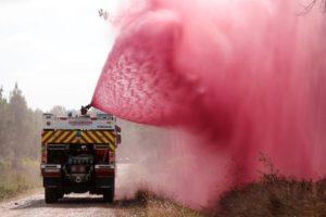 large quantity of red flame retardant sprayed from fire truck