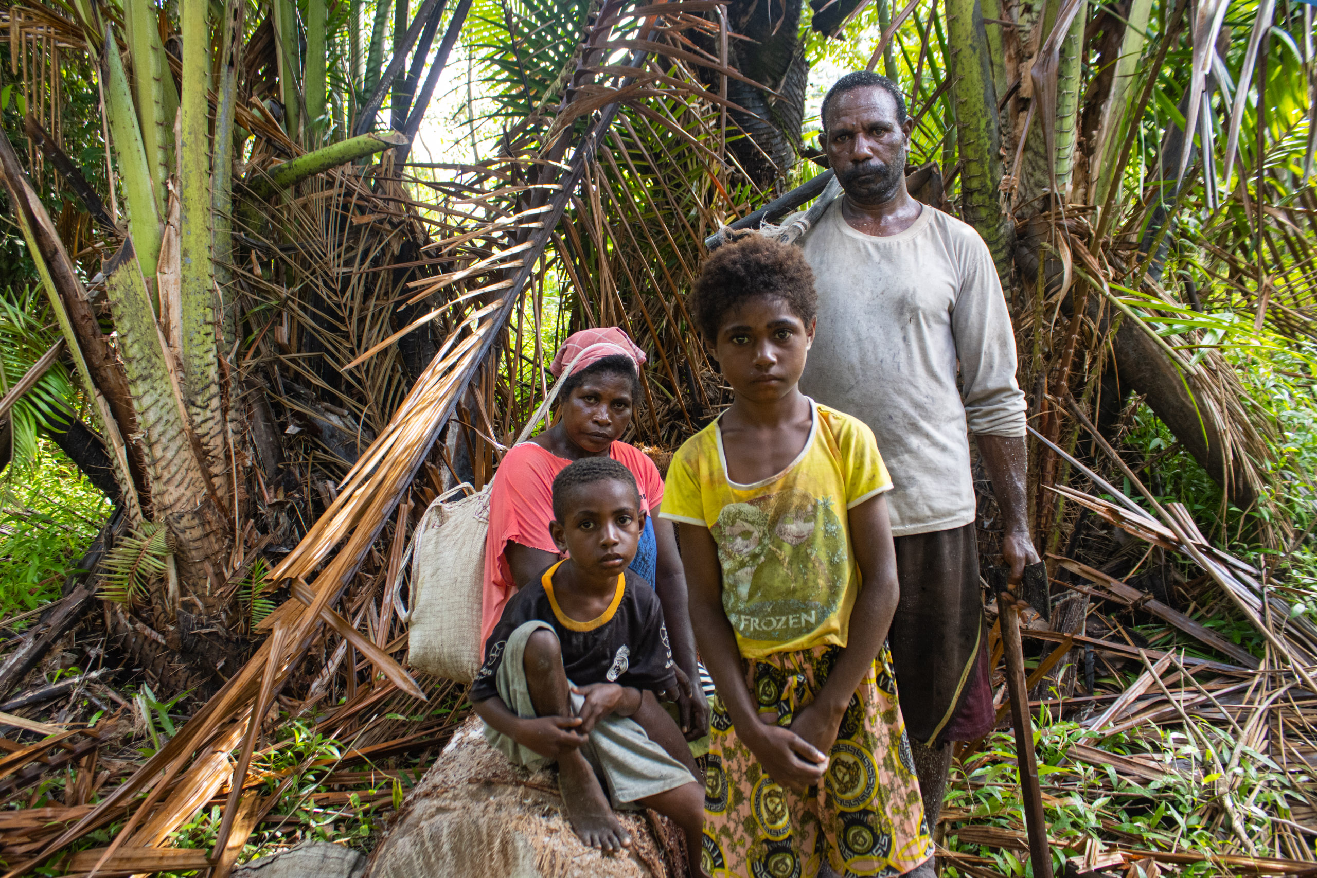 Locals with their children next to their sago palms