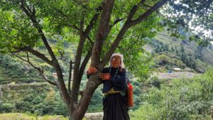 Juthi Devi, daughter-in-law of one of the pioneers of the Chipko movement, clasps the trunk of a tree in Raini village
