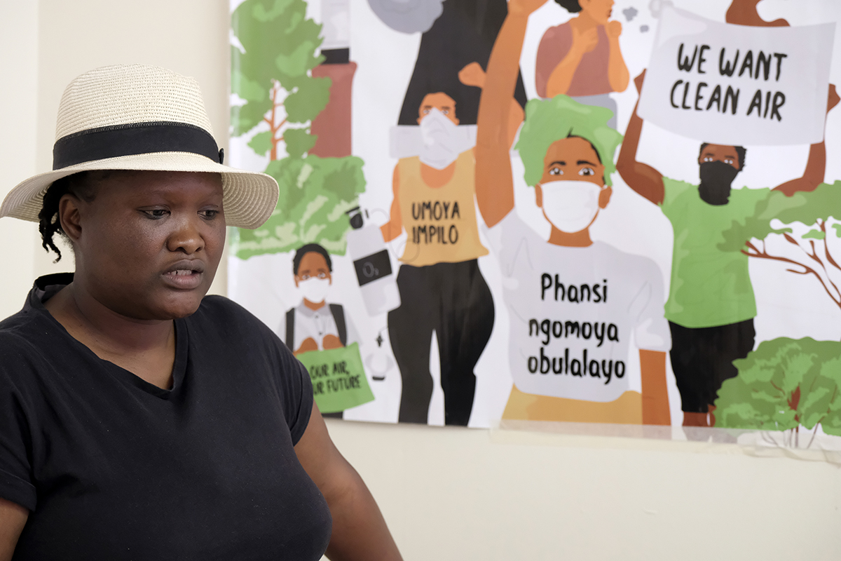 woman in front of poster depicting clean air protest