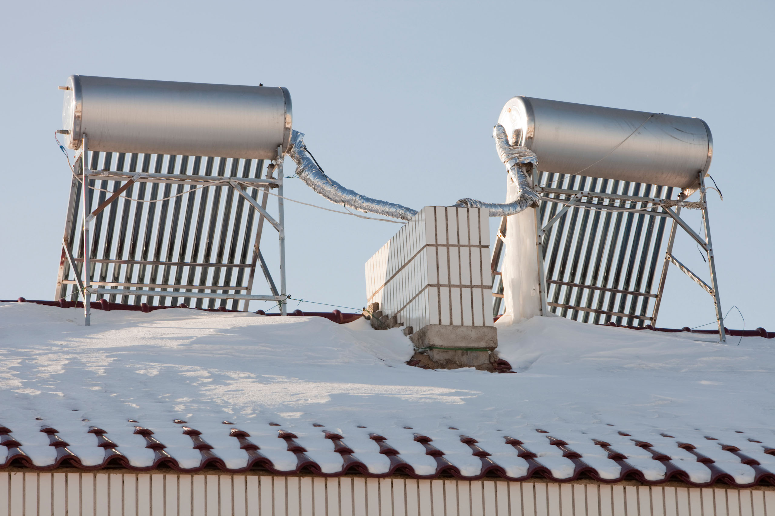 solar water heaters on the snow-covered roof of an apartment in Heilongjiang province in northern China