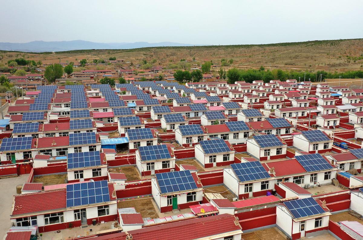 aerial view of solar panels of the roofs of rows of small houses, rural China