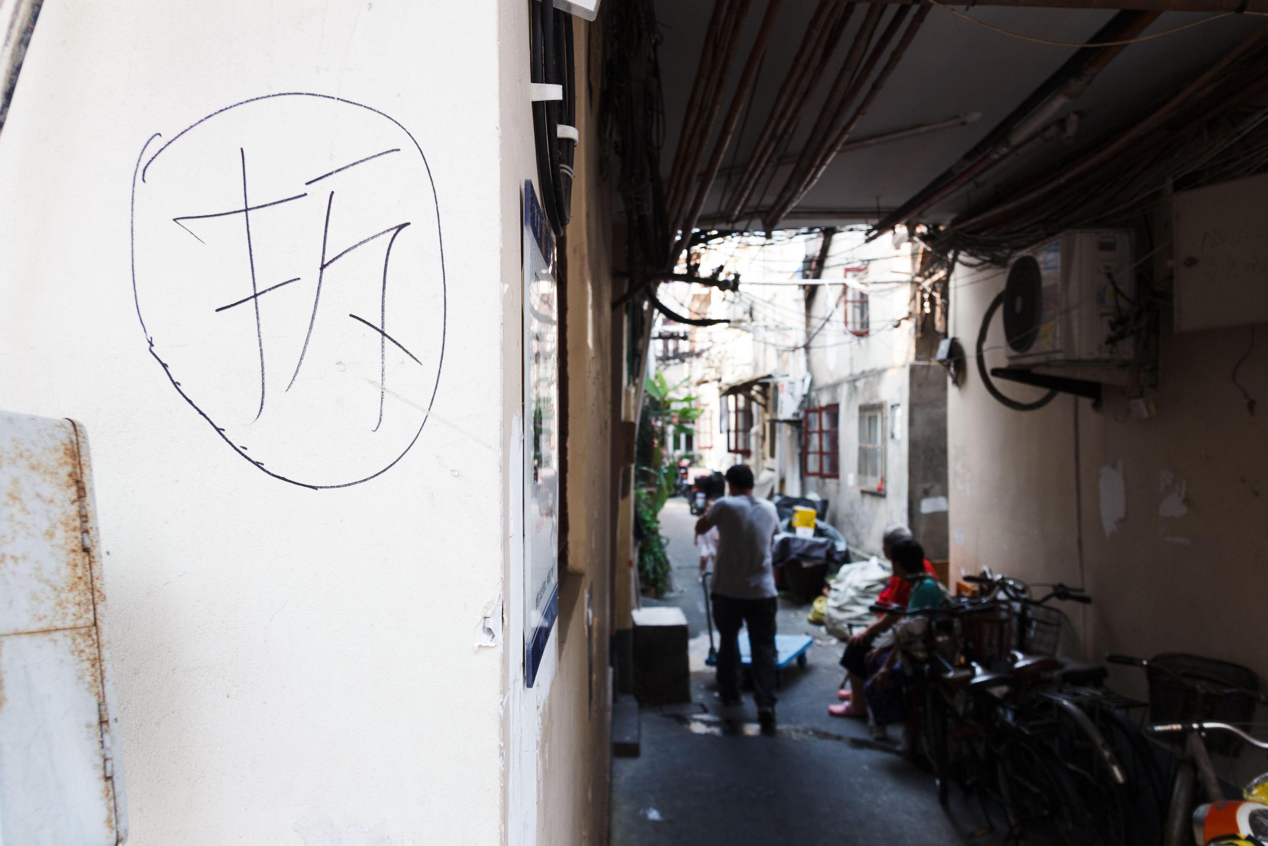 Chinese character for 'demolish' written in black on old building in Laoximen neighbourhood in Shanghai, china demolition