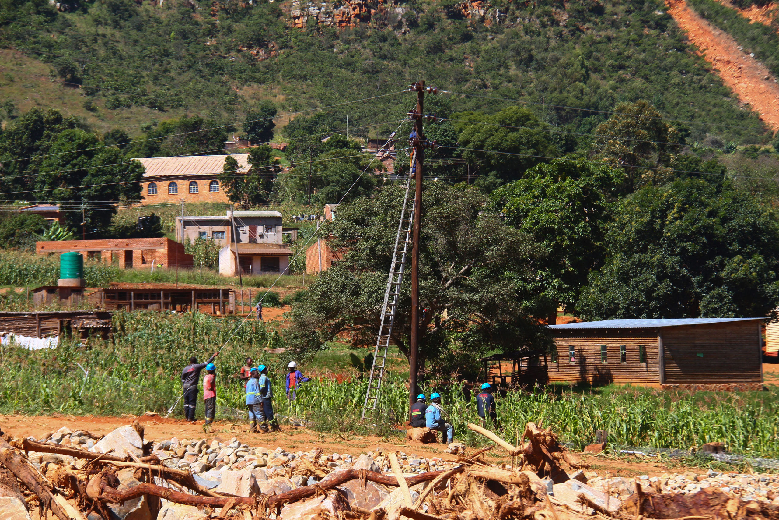 Electricians repairing electrical cables attached to pole