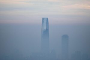 two skyscrapers poke out of the top of layer of smog, mist