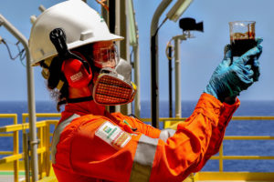man in high vis jacket holding a jar of oil
